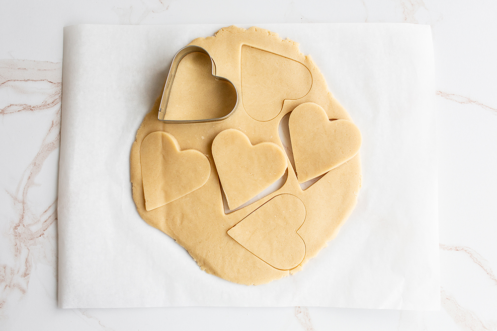 cutting out the hearts from the cookie dough.