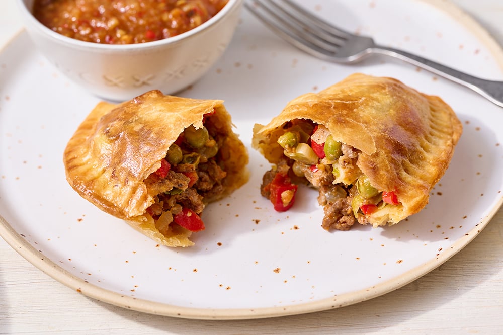 beef empanada on a plate with some salsa for dipping