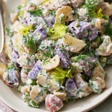 fresh potato salad in a serving dish made with Greek yogurt, sour cream, lemon juice, and dill