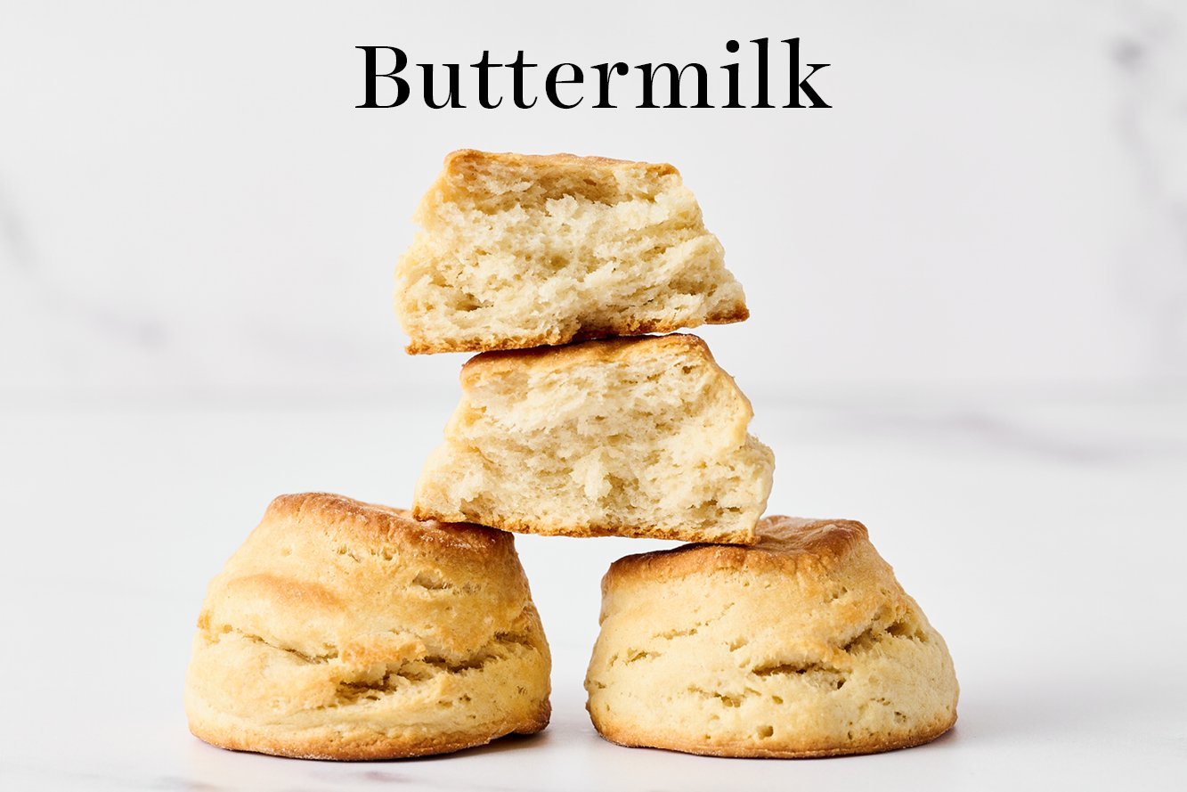 buttermilk biscuits stacked in a pyramid, with one torn open so you can see the inside of the biscuit 