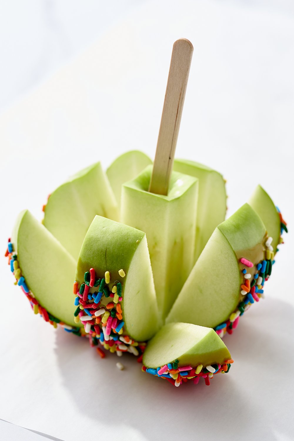 a caramel apple sliced up, ready to serve.