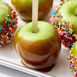 caramel apple on a baking sheet with a few more behind.