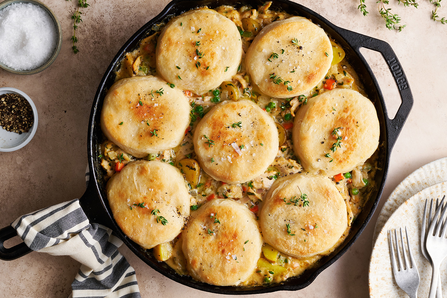 a hot skillet full of chicken pot pie with biscuits, ready to serve