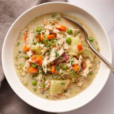 bowl of turkey pot pie soup being served with a spoon