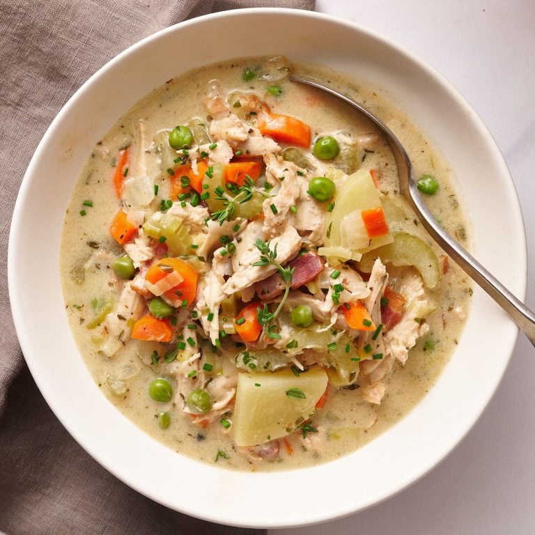 bowl of turkey pot pie soup being served with a spoon