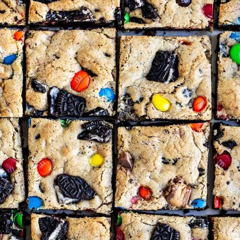 the whole pan of loaded cookie bars, full of Oreos and leftover Halloween candy, sliced and ready to serve.