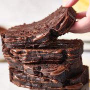 hand grabbing a slice of a stack of chocolate banana bread slices