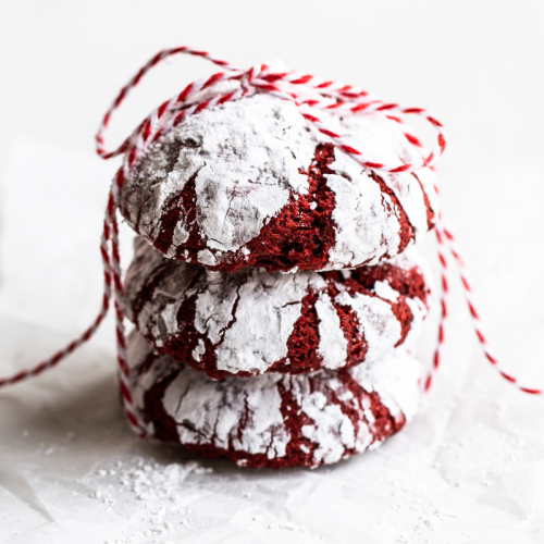 a stack of three red velvet crinkle cookies, tied together with red and white twine.