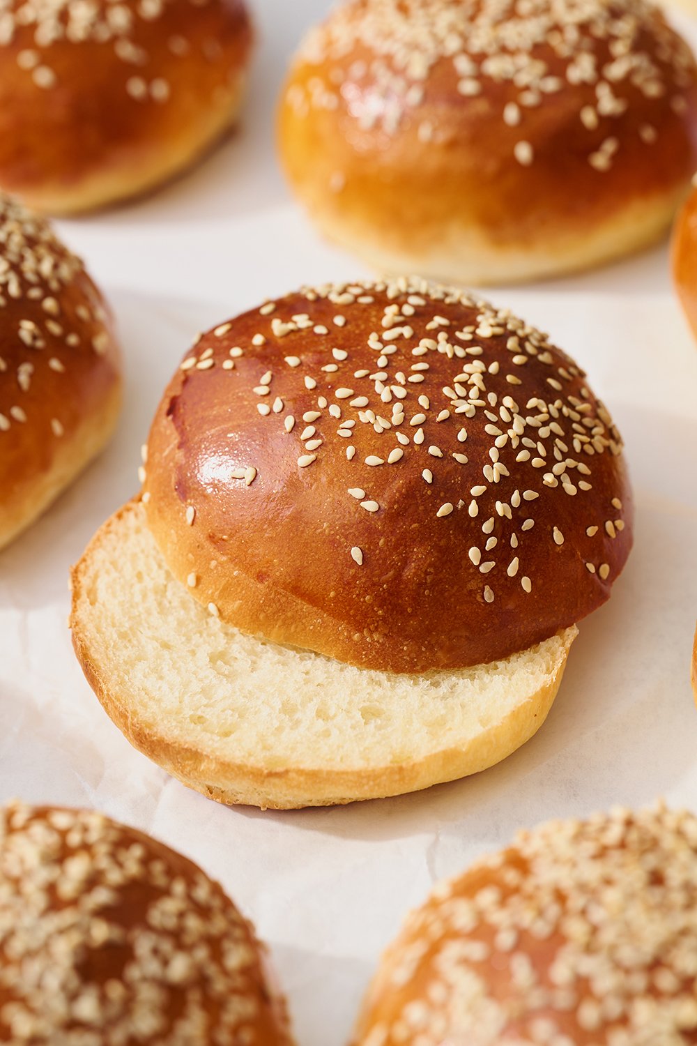 homemade burger bun with sesame seeds on top sliced in half - perfect for your burgers and BBQ sandwiches!