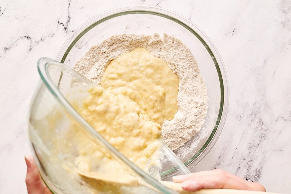 Adding wet ingredients to dry ingredients for banana bread