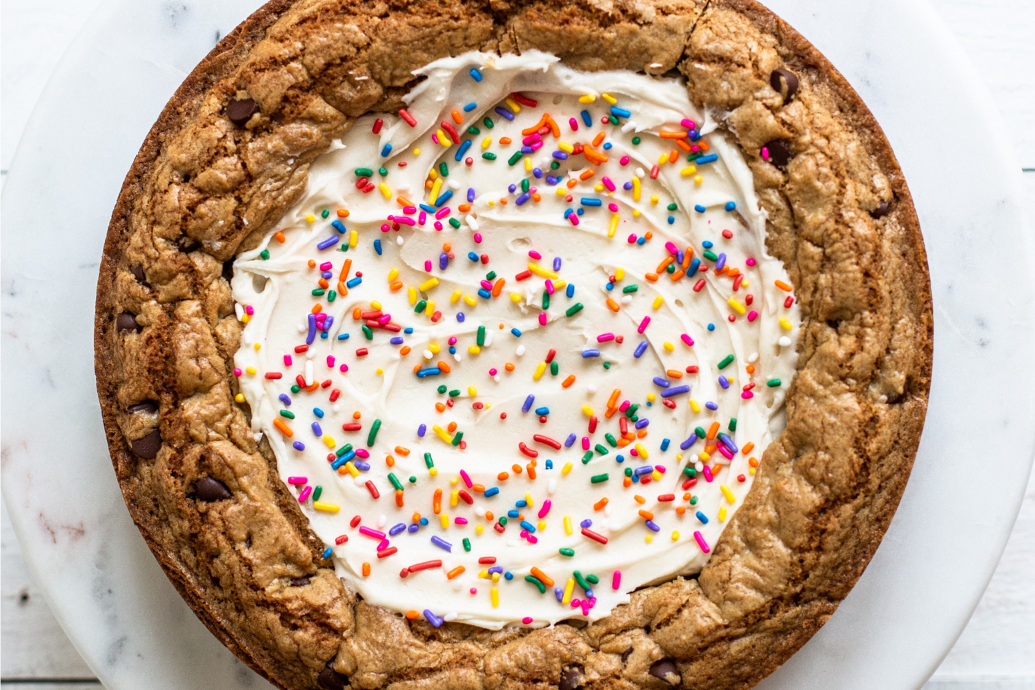 full baked cookie cake with frosting.