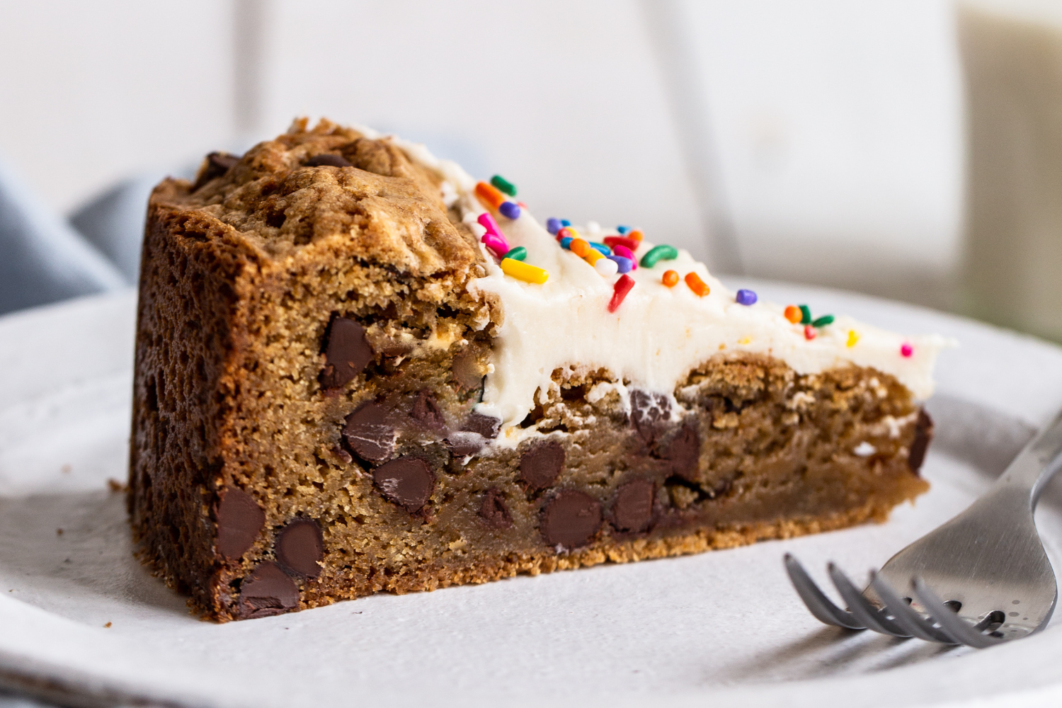 a slice of cookie cake on a plate, ready to be served.