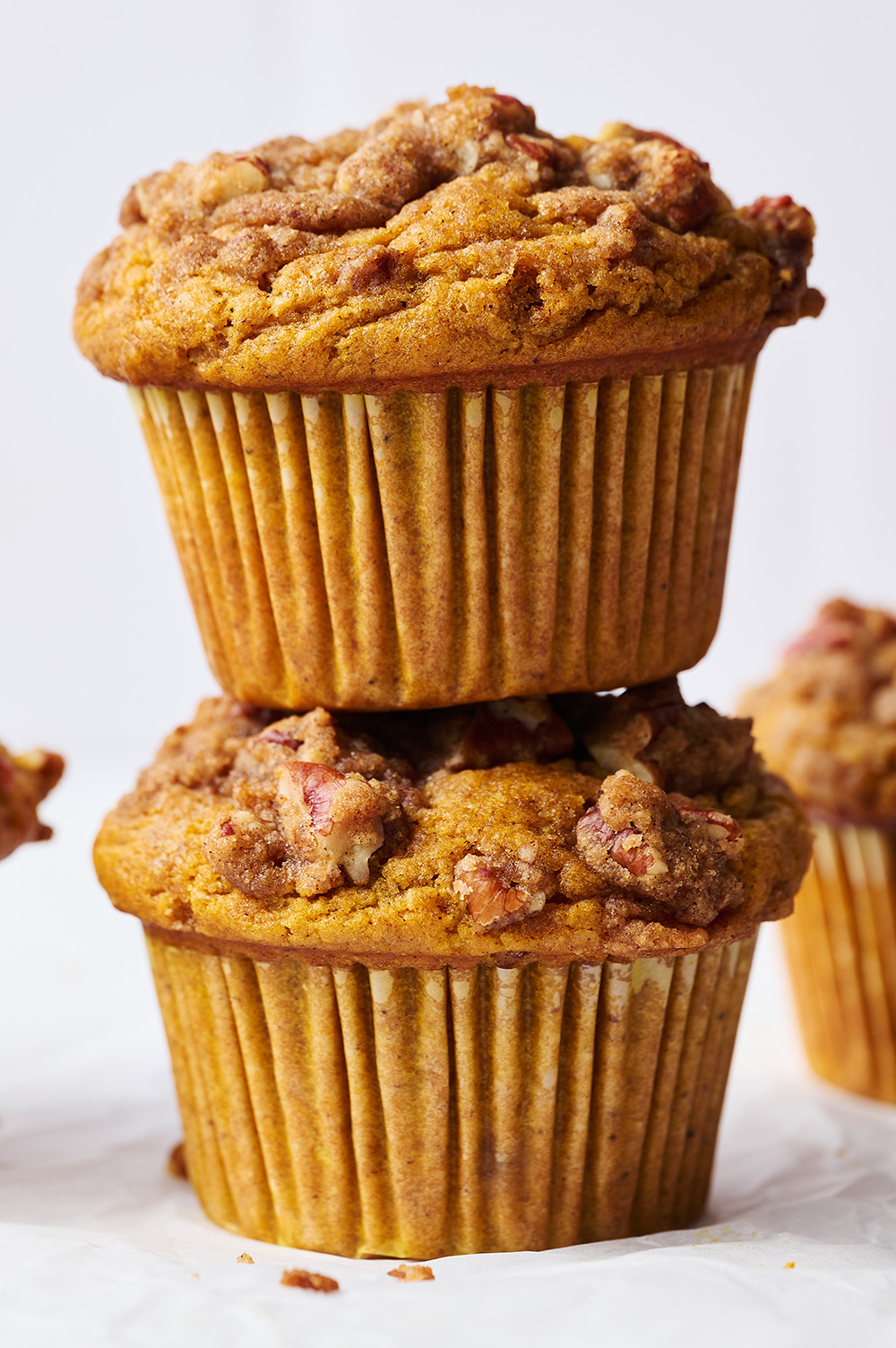 one pumpkin muffins stacked on top of another pumpkin muffin