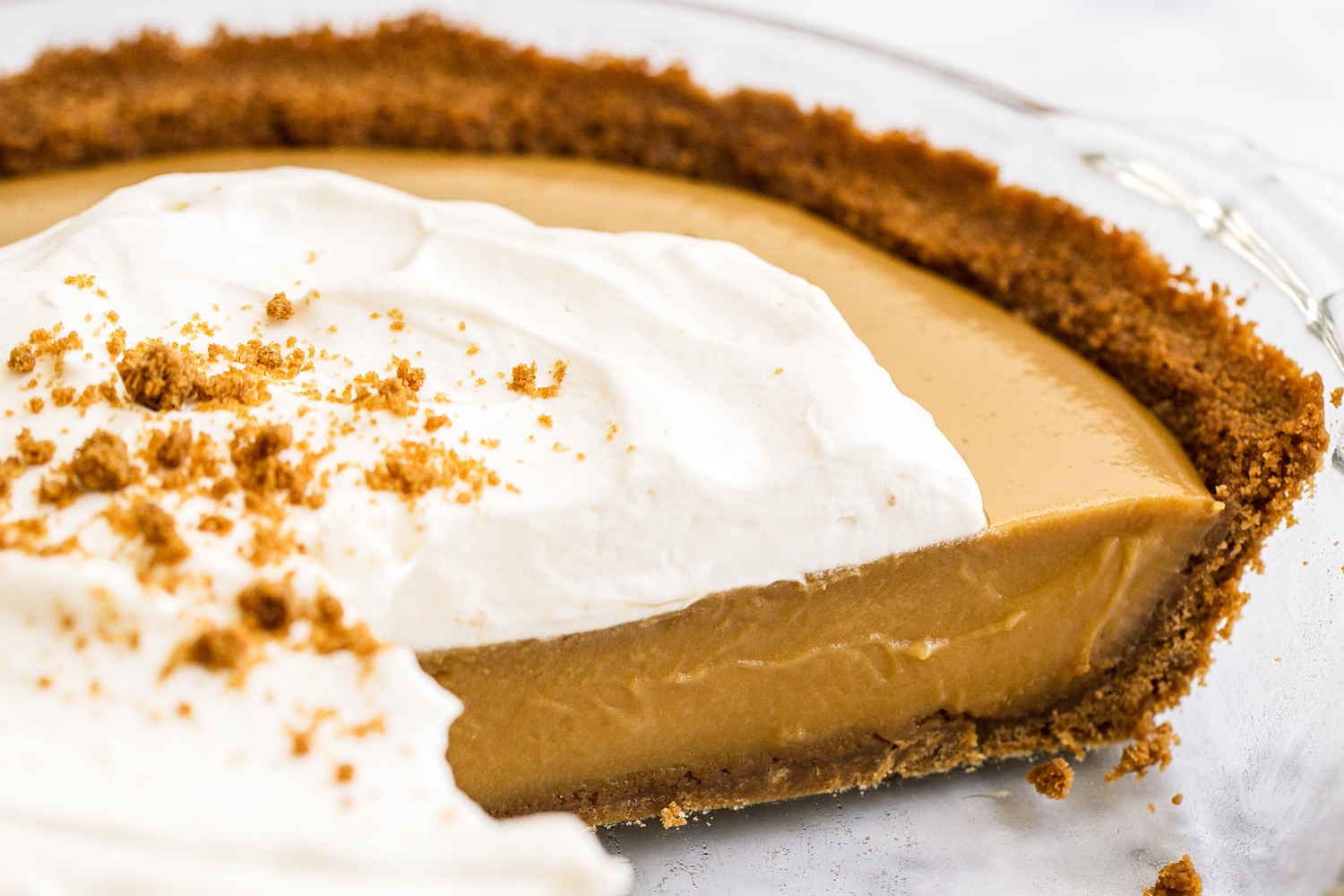 closeup of this butterscotch pudding pie, showing the creamy texture of the filling and the fluffy whipped cream on top.