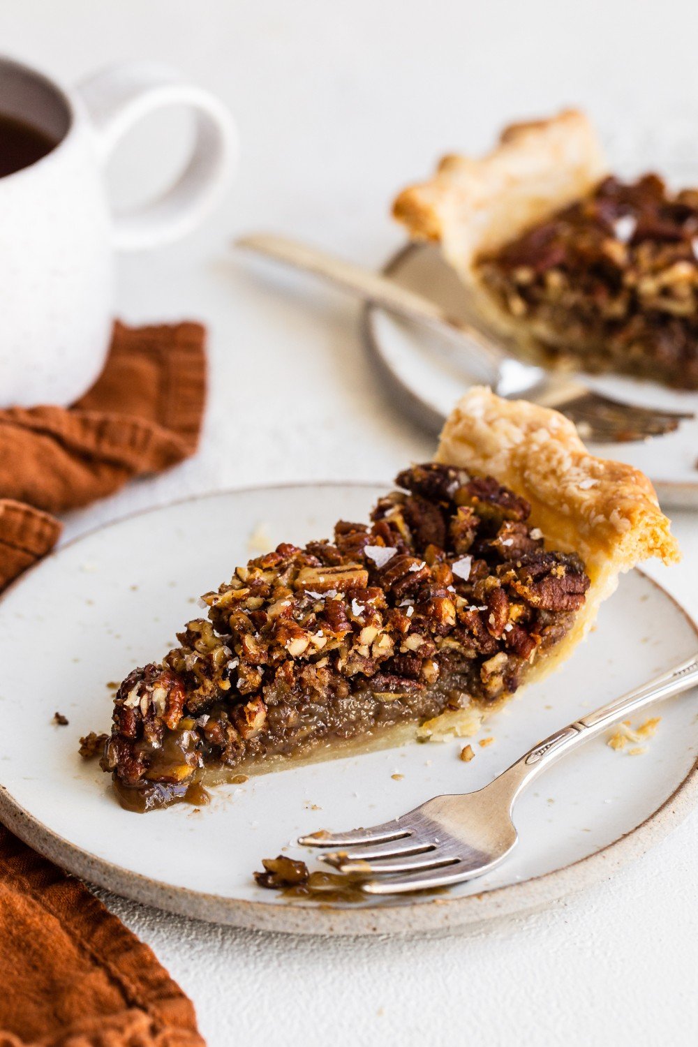 a slice of pecan pie on a plate with a fork.