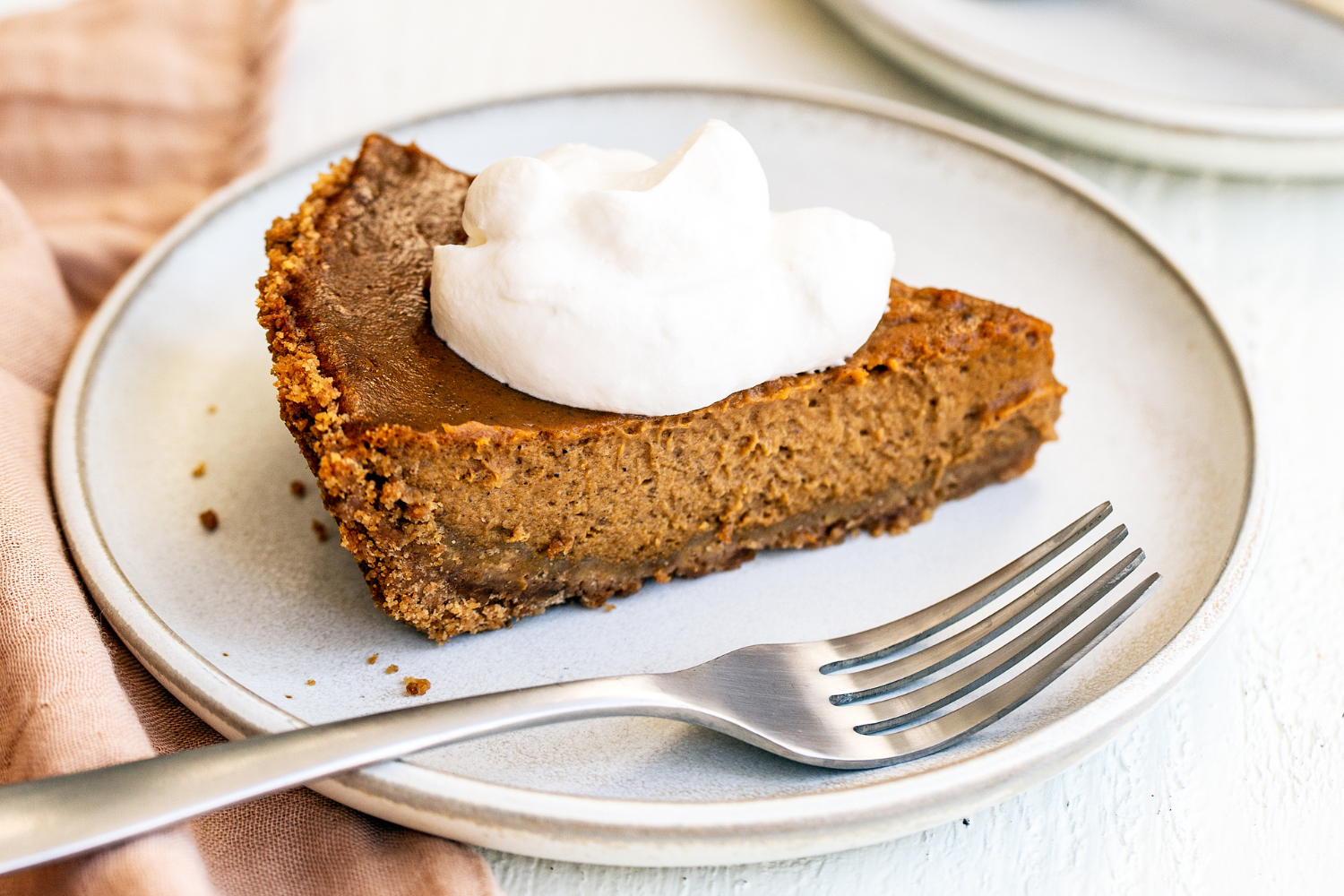 easy pumpkin pie slice with a dollop of whipped cream, with a fork on a plate.