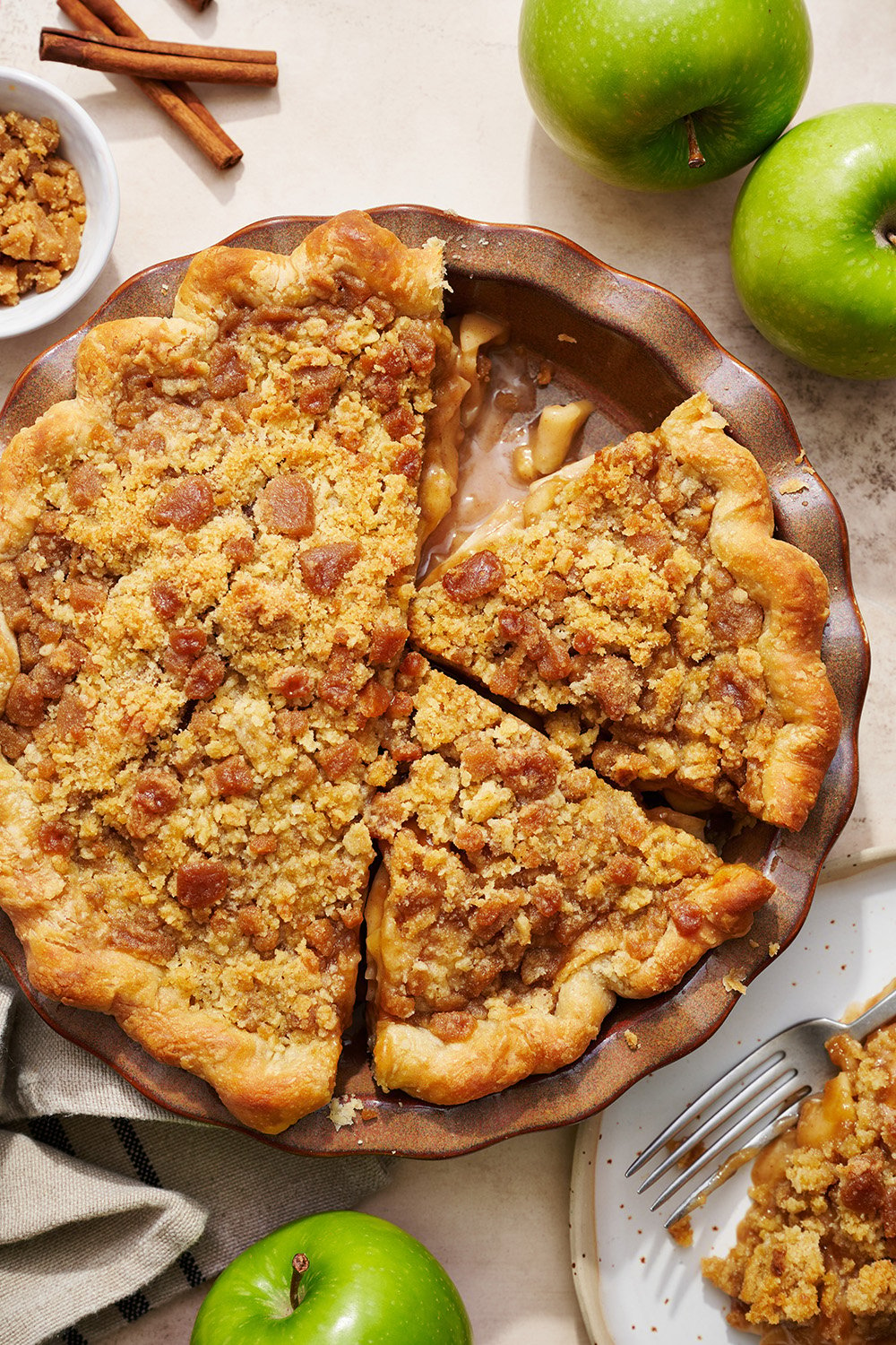 the whole apple streusel pie being sliced up before serving.