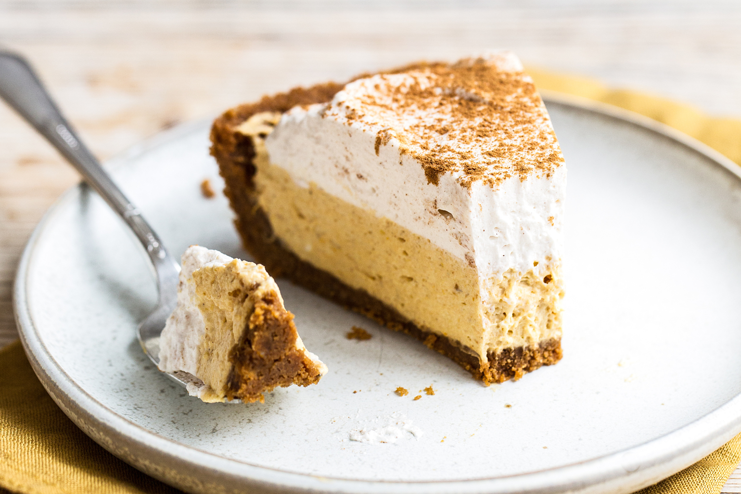 a slice of no-bake pumpkin mousse pie on a plate with a fork.