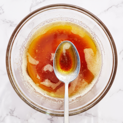 a bowl of browned butter in a glass bowl with a spoon.