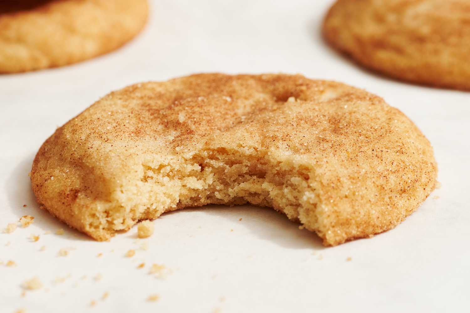 one snickerdoodle cookie with a bite taken out.