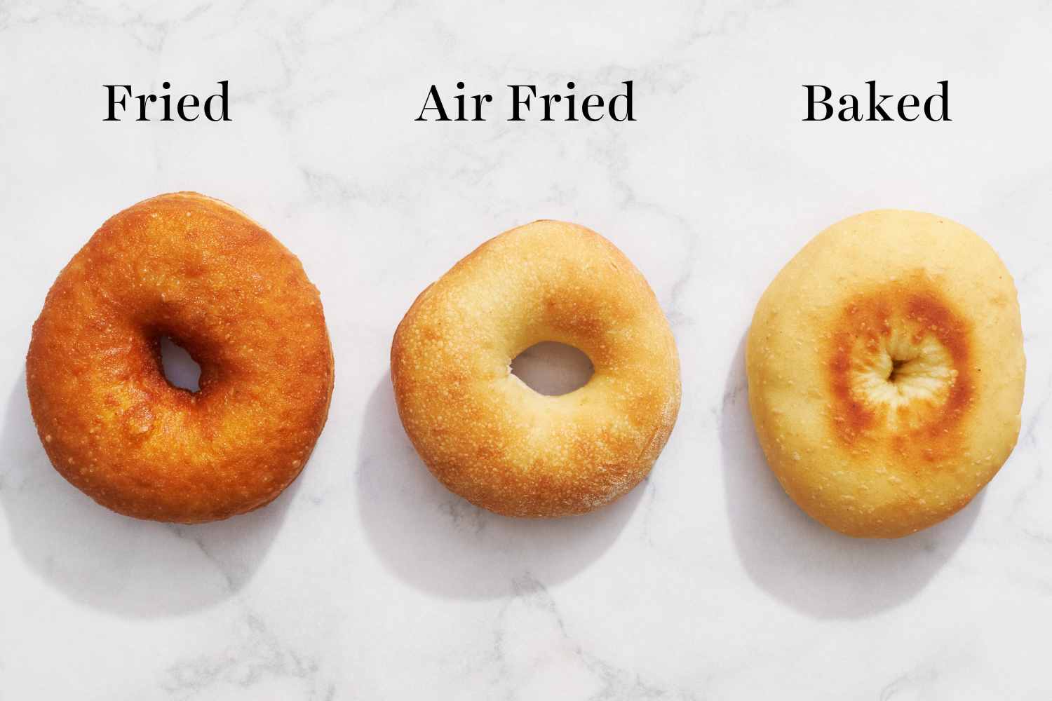 three donuts all cooked differently (fried vs. air fried vs. baked), side-by-side to compare.