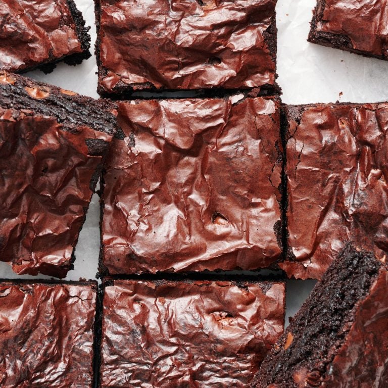 slices of brownies with ultra shiny, crinkly crust, with some slices turned slightly to show their thick, chewy, fudgy interior.