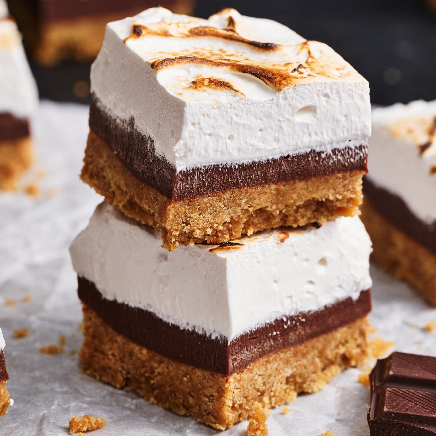 two s'mores fudge bars stacked on top of one another, with more bars in the background.