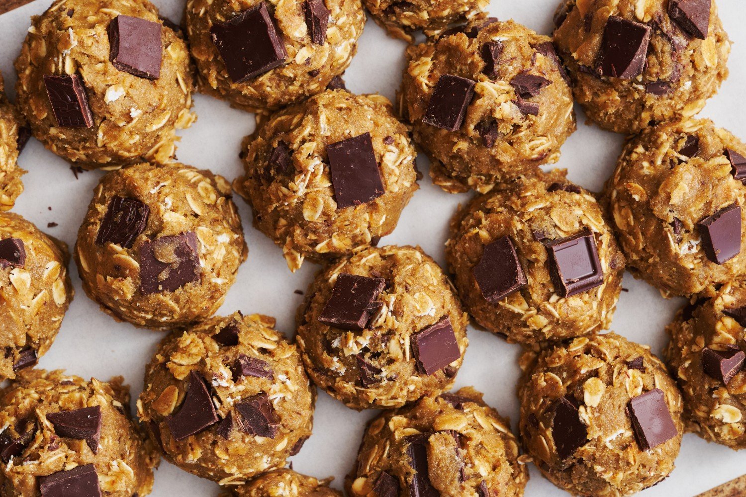 balls of Bourbon Rye Oatmeal Chocolate Chunk Cookie dough, ready to bake.