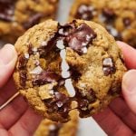 a warm Bourbon Rye Oatmeal Chocolate Chunk Cookie being pulled apart, with gooey chocolate between the two halves.