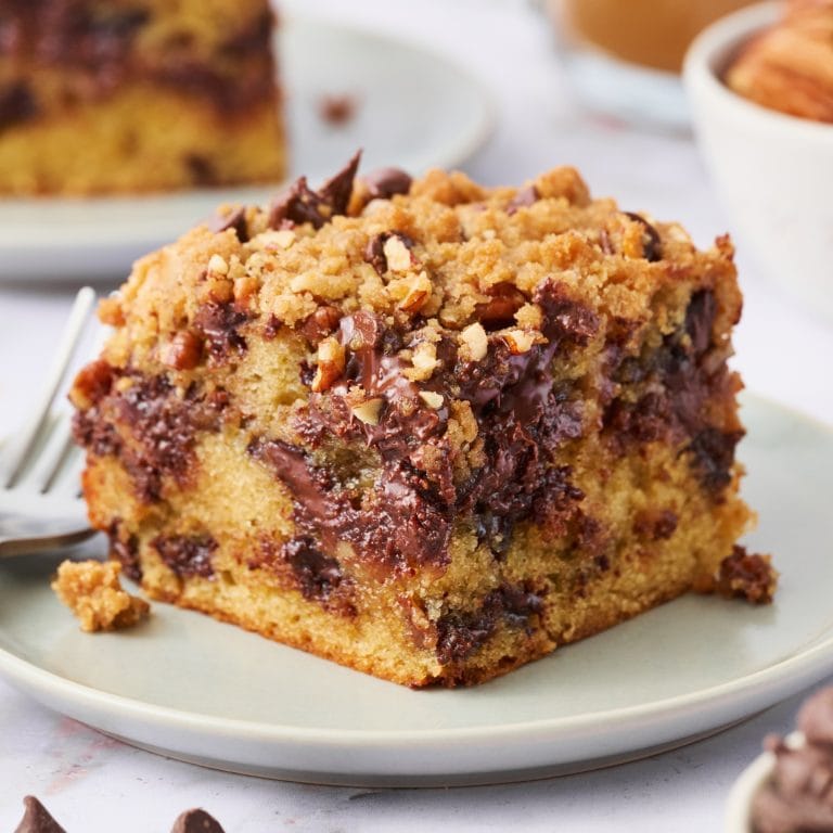 a slice of Chocolate Chip Coffee Cake on a white plate with a fork.