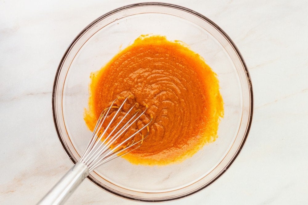 clear bowl with melted butter and other wet ingredients for pumpkin bars