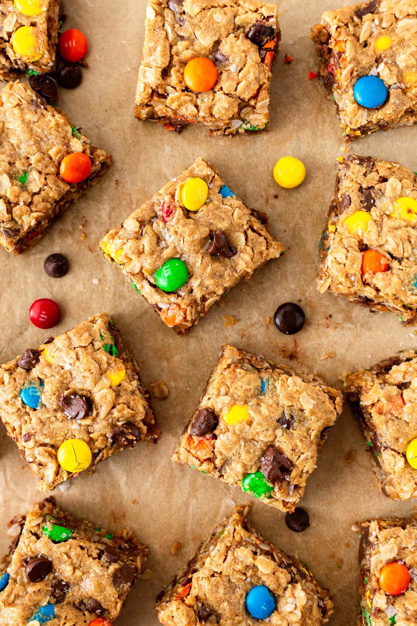 overhead of monster cookie bars sliced and laid on parchment with m&ms
