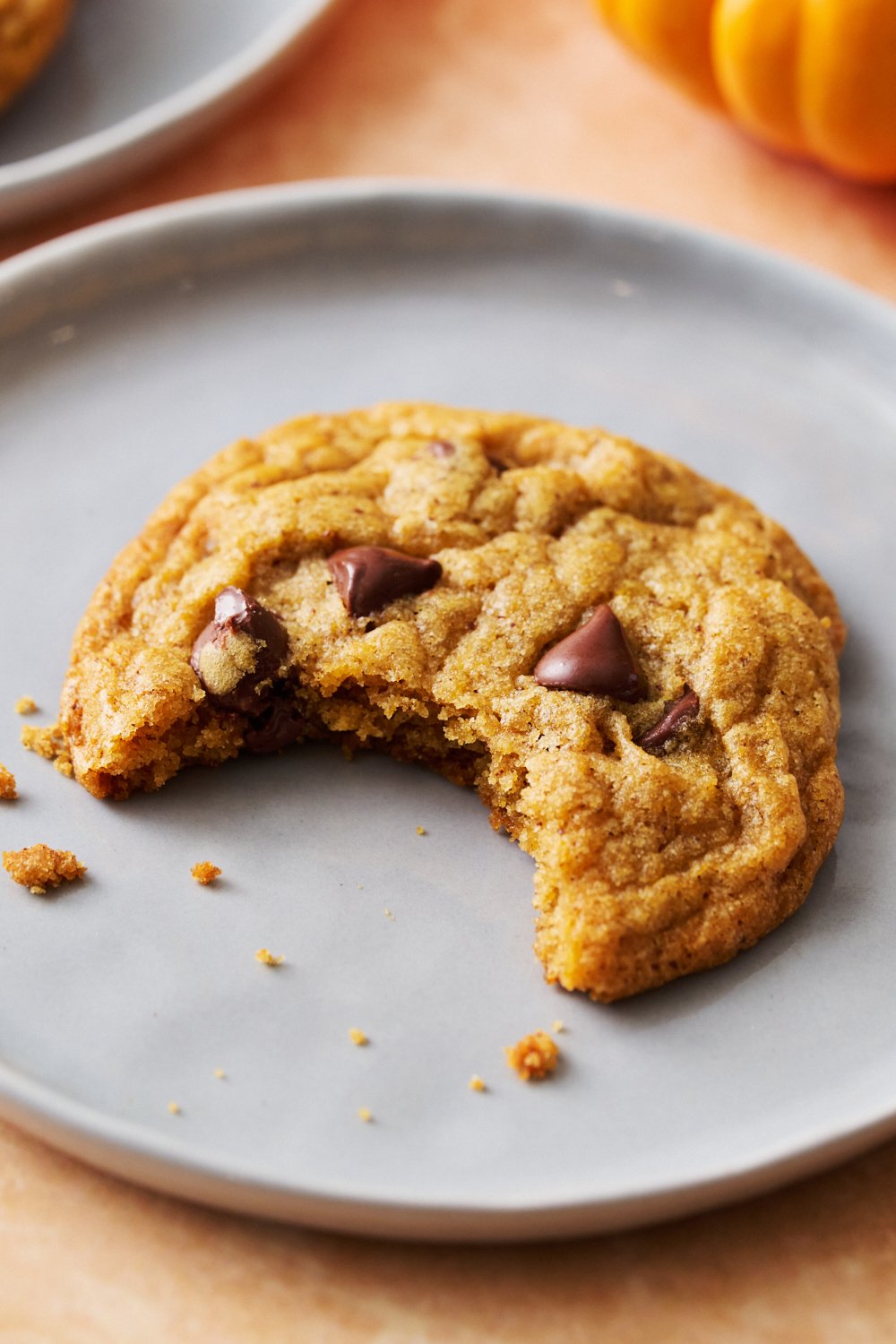 pumpkin cookie on a plate with a bite taken out.