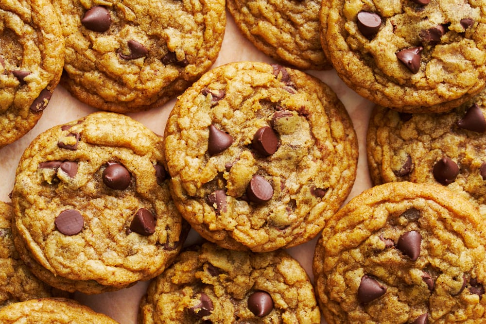 chocolate chip pumpkin cookies piled on a pale brown background.