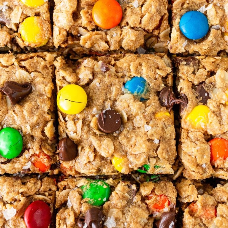 squares of monster cookie bar with chocolate chips and rainbow M&Ms throughout.