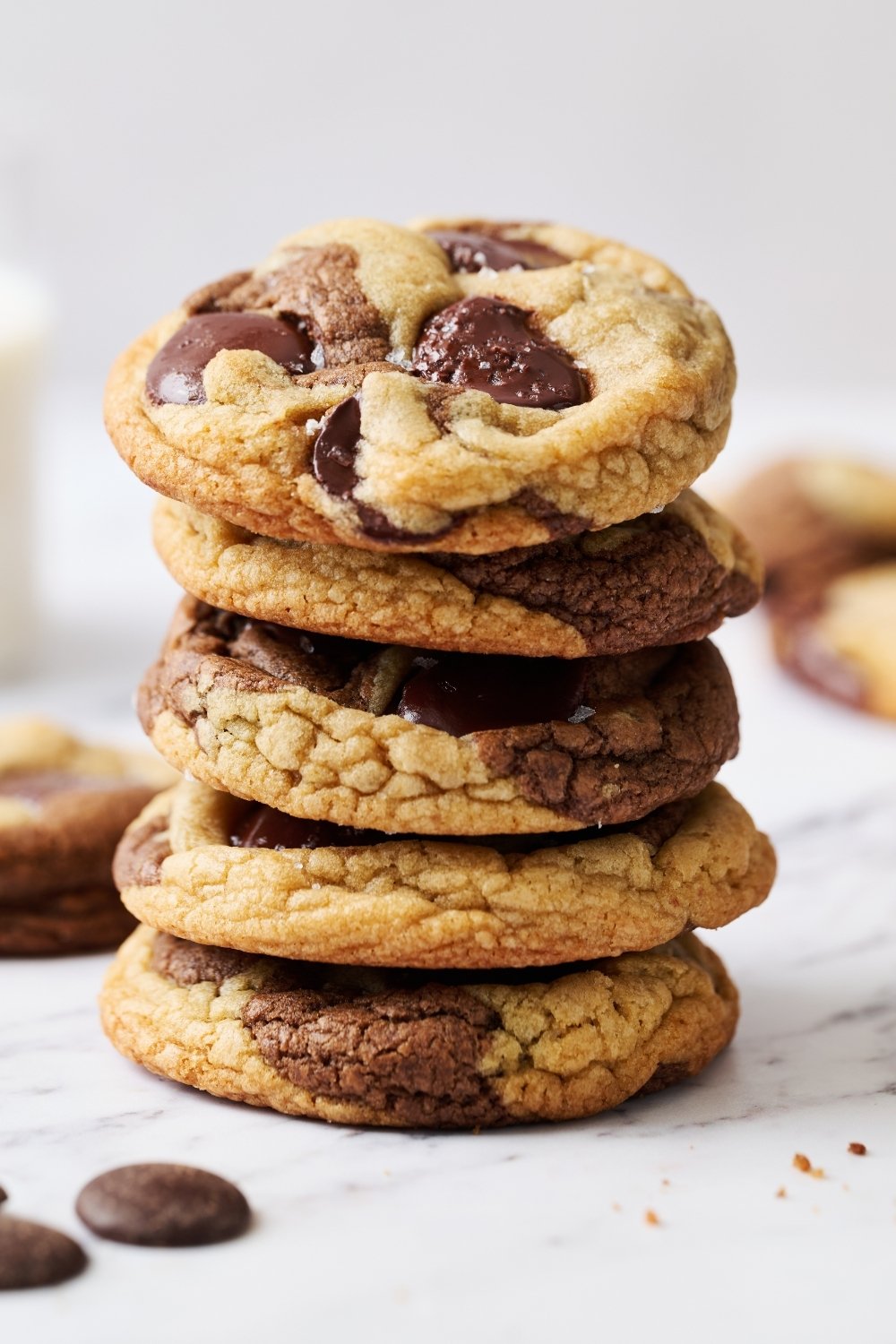 a stack of Chocolate Chip Marbled Cookies, with a glass of milk behind.