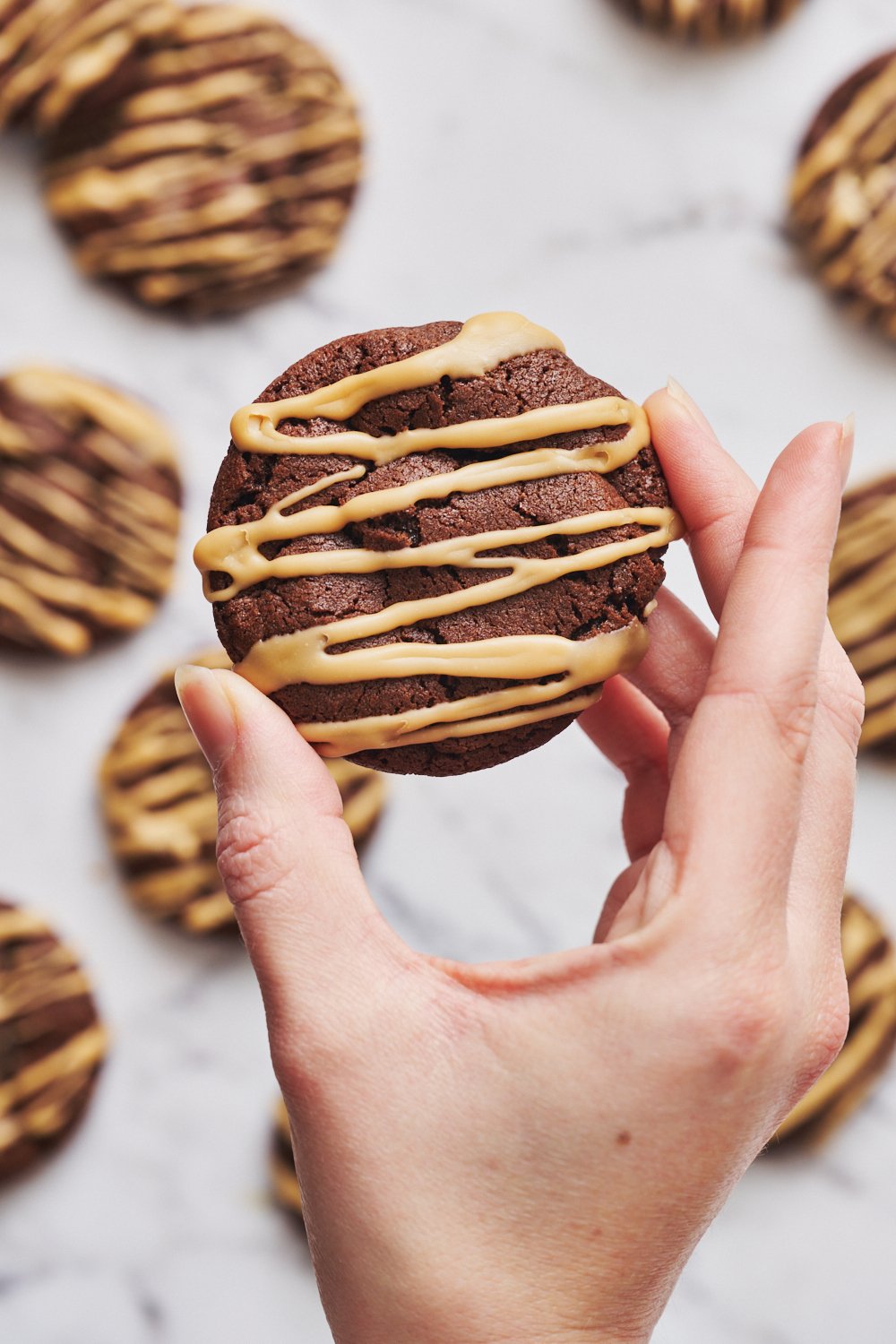 a hand holding an espresso martini cookie with Kahlua glaze.