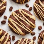 an espresso martini cookie drizzled with coffee liqueur glaze, surrounded by coffee beans and more cookies.