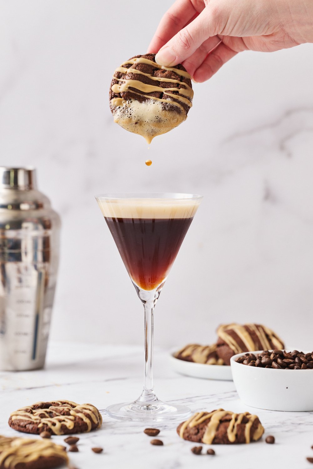 an espresso martini cookie being dipped in an espresso martini cocktail. 