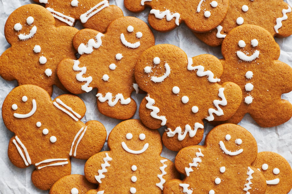 a pile of gingerbread men decorated with white icing.