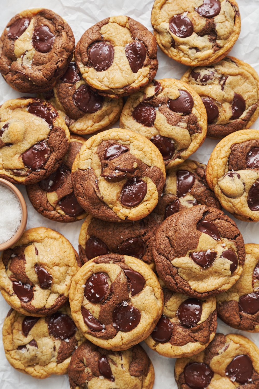 the whole batch of Marbled Chocolate Chip Cookies with a small bowl of flaky sea salt nearby. 