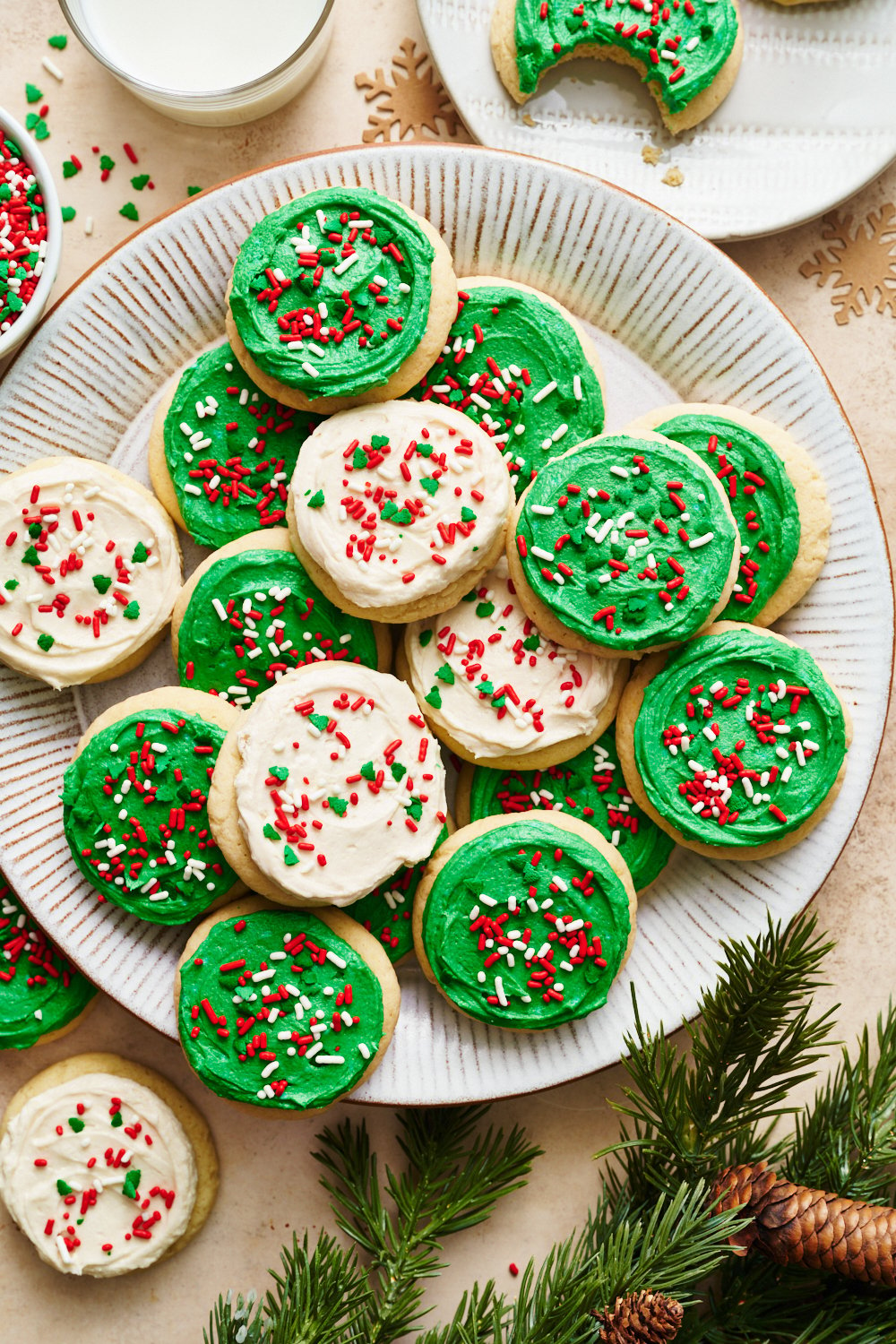 a platter of Christmas Lofthouse cookies iced in white and green with holiday sprinkles.