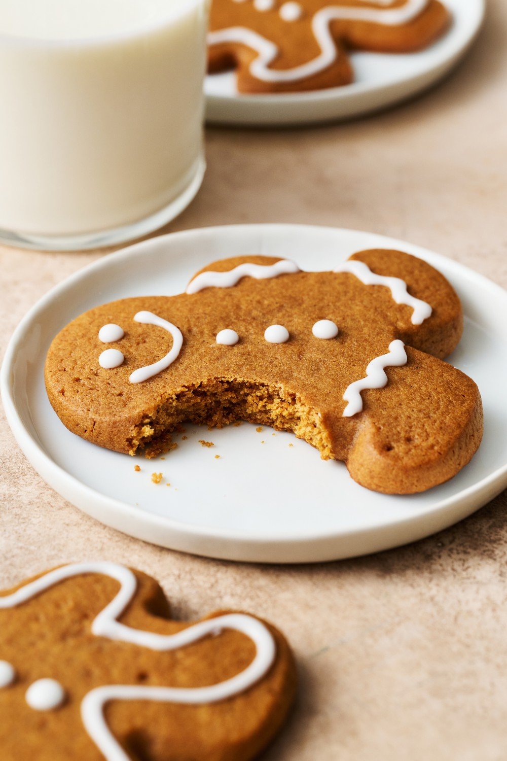 a gingerbread cookie on a small white plate with a bite taken out.