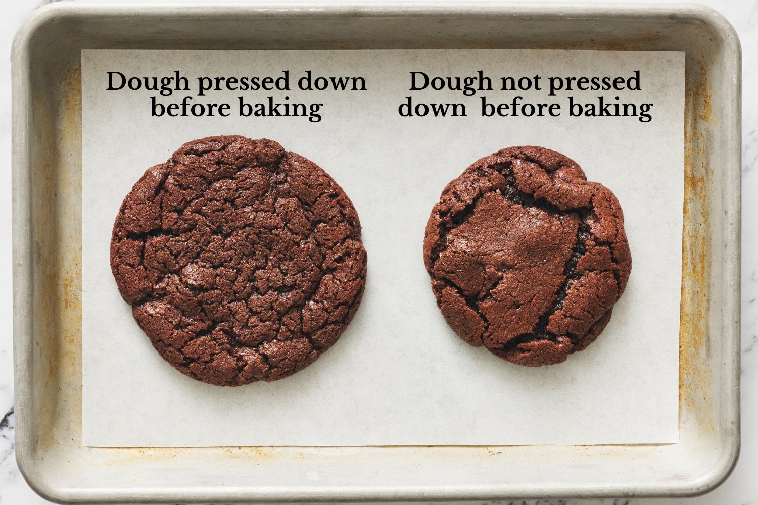 two side-by-side cookies on a baking tray to compare pressing down on the cookie dough balls before baking, vs. leaving them in balls.