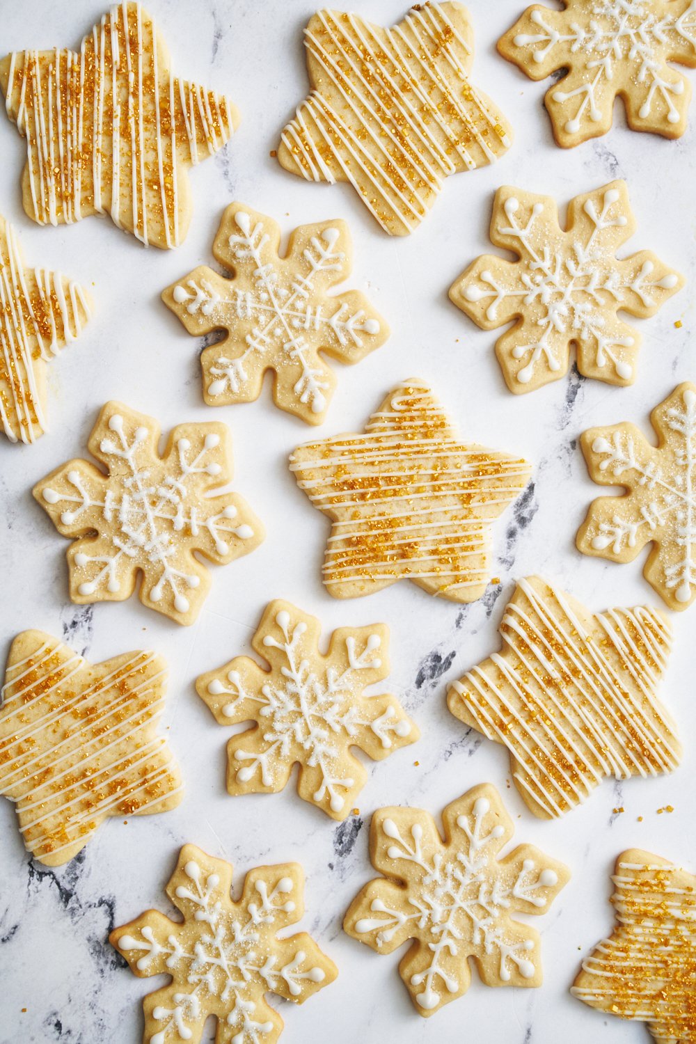 sugar cookies in star and snowflake shapes, decorated with cookie icing and sugar sprinkles.