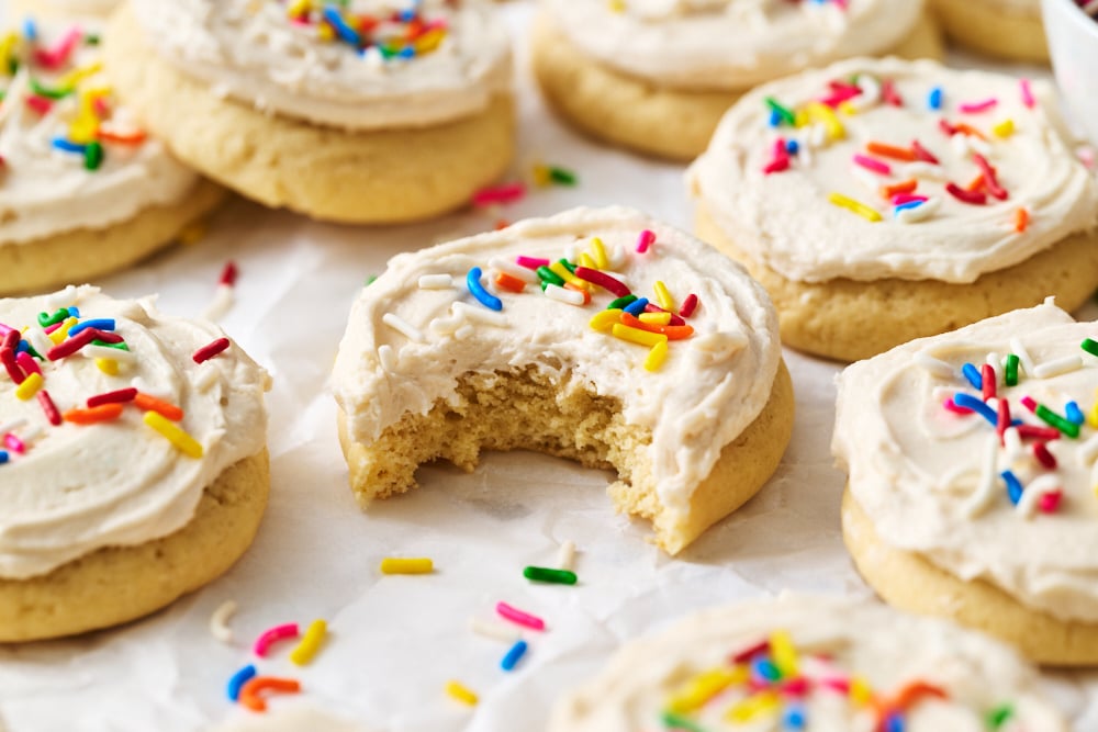 a Lofthouse Cookie with white icing and rainbow sprinkles with a bite taken out.