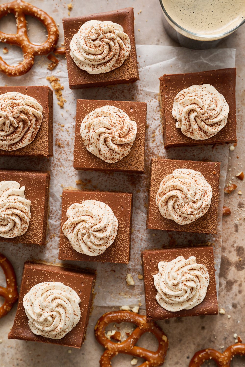 the whole batch of beer cheesecake bars with whipped cream piped on top of each.