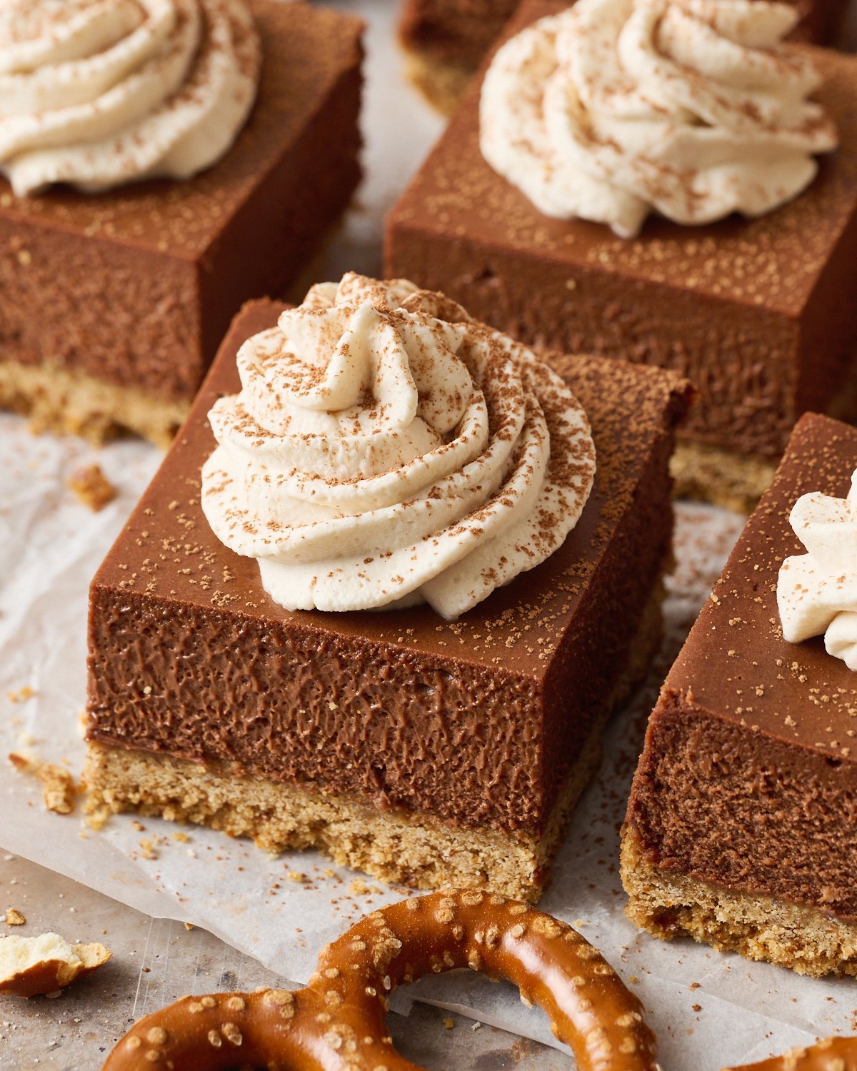 slices of Chocolate Stout Cheesecake Bars on parchment paper, ready to serve.