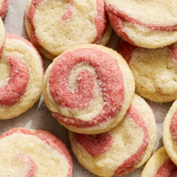 several strawberry swirl cookies on parchment paper.