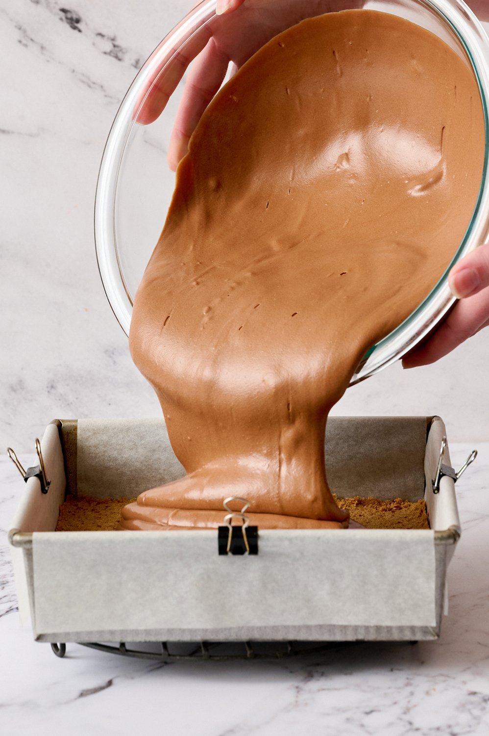 pouring the batter over the cooled crust before baking.